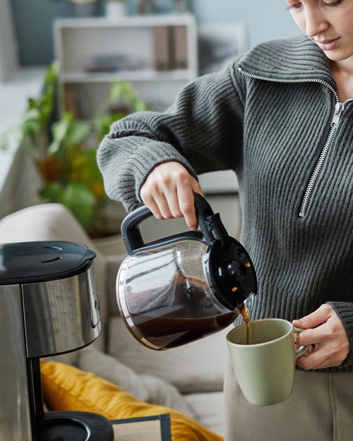 Woman pouring coffee into a mug
