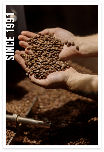 Hands holding coffee beans with text overlay "Since 1991"